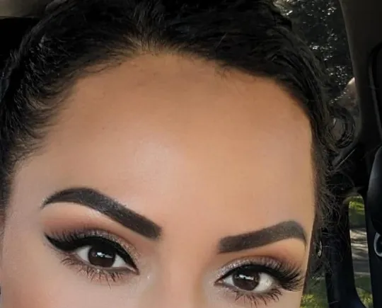 Client selfie showing healed, defined brows